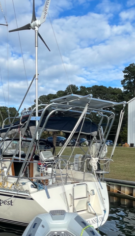 Atlantic Towers Arch installed on a Caliber sailboat, featuring a wind turbine and a shaded cockpit area.