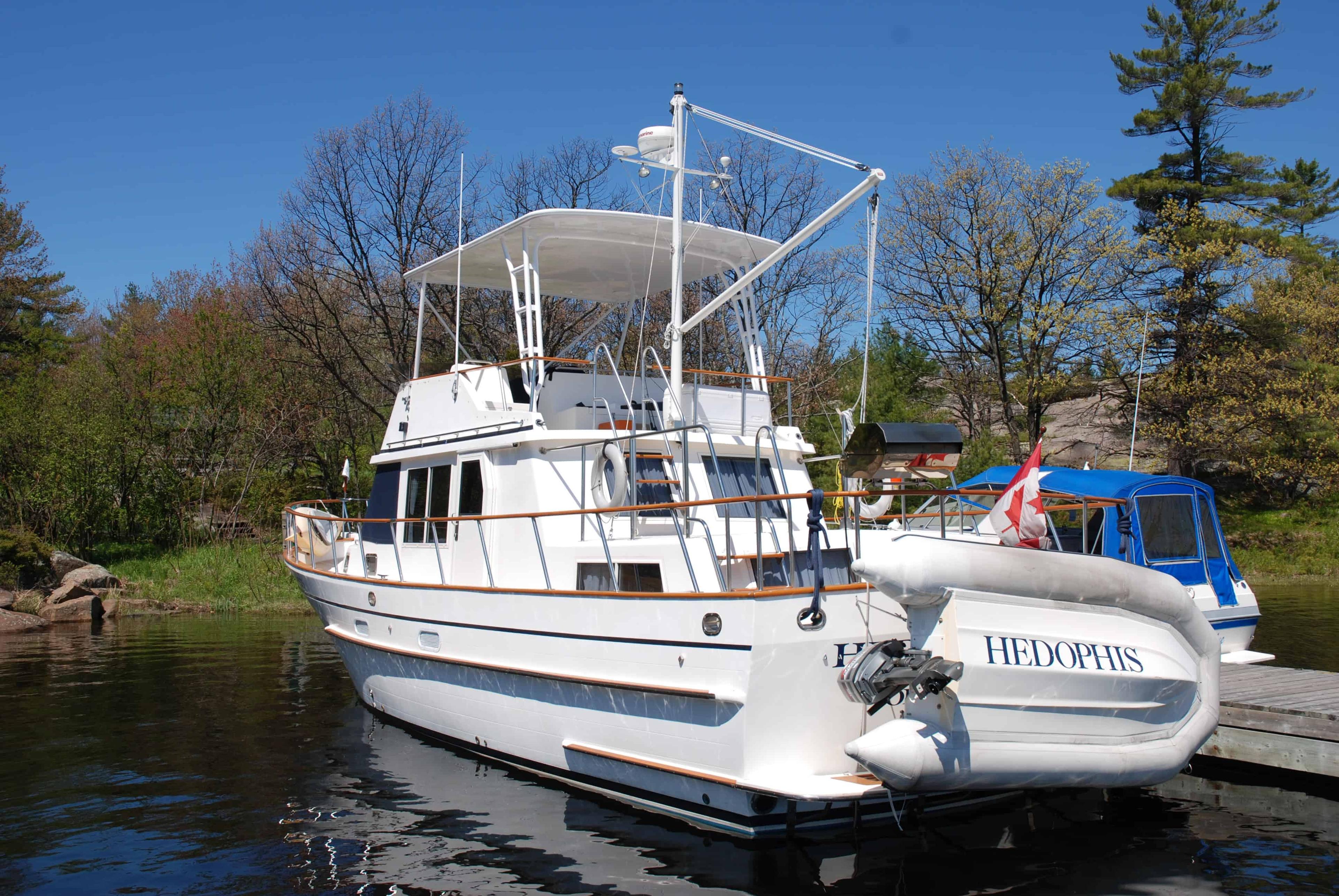 Atlantic Towers Top installed on a Monk 42 Trawler anchored by a wooden dock, surrounded by greenery.