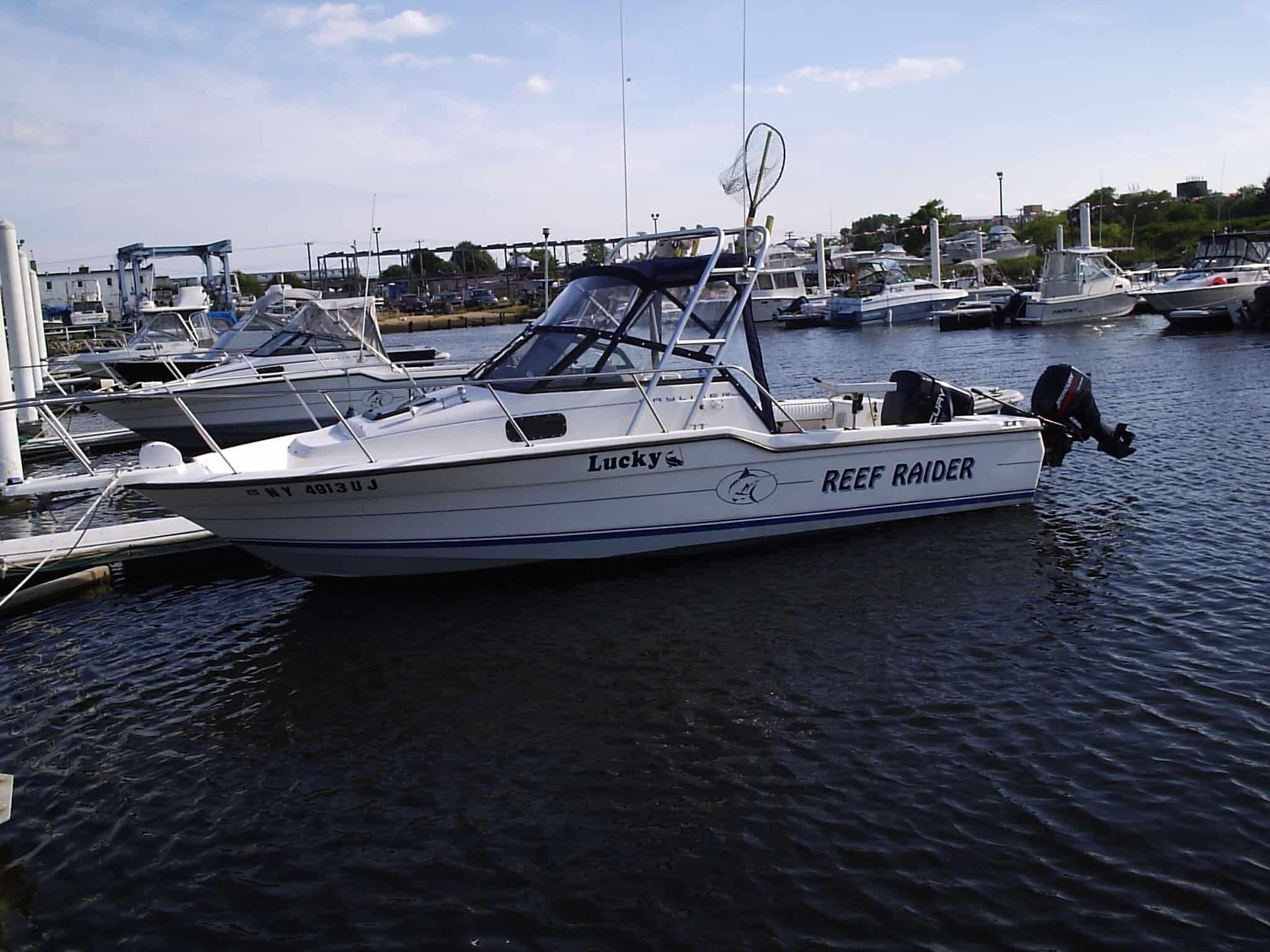 Atlantic Towers Arch installed on a Trophy 2302 Walkaround boat named "Lucky's Reef Raider" docked at a marina.