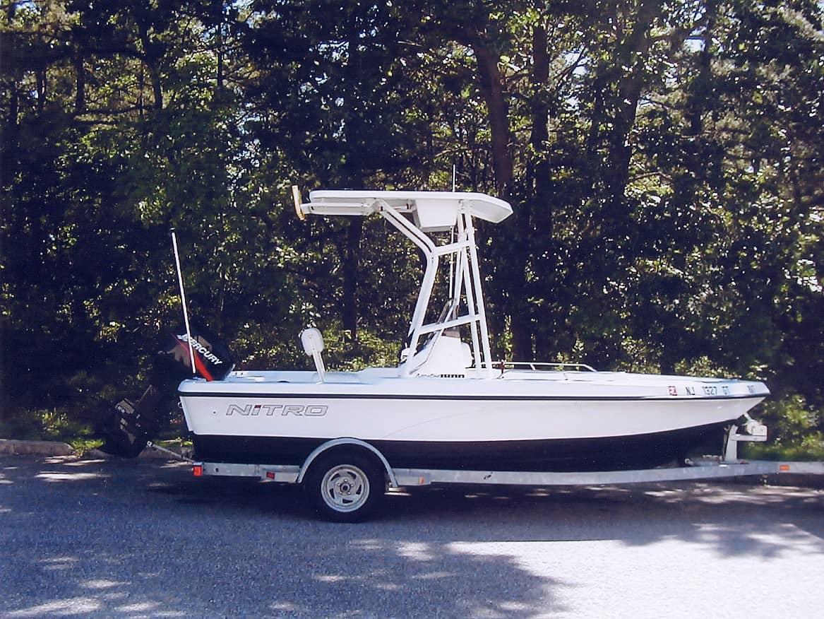 Atlantic Towers T-Top installed on a Nitro 1800 Center Console boat parked on a gravel surface, surrounded by trees.