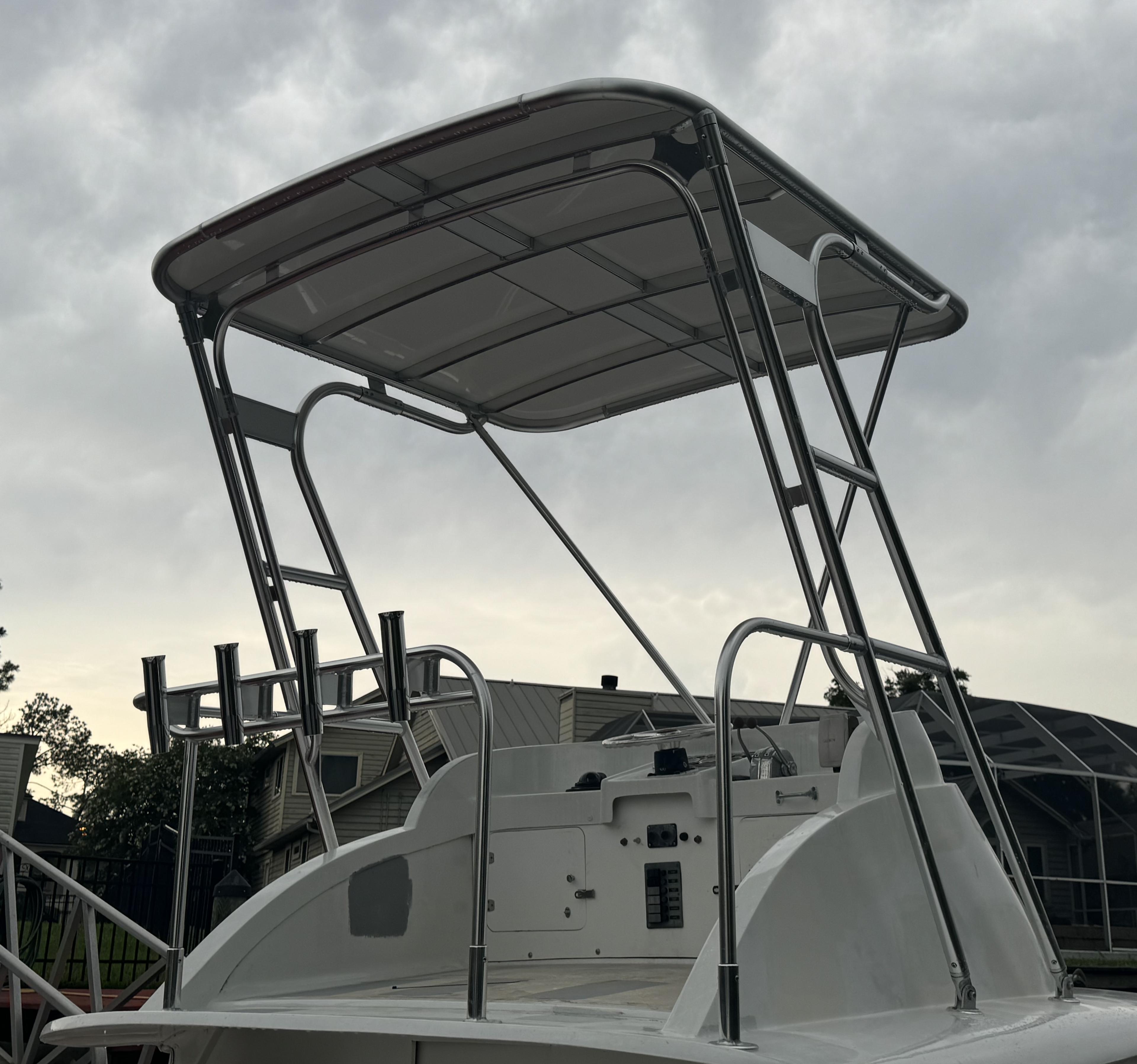 Atlantic Towers Top installed on a Bertram boat with stainless steel frame and rod holders under a cloudy sky background