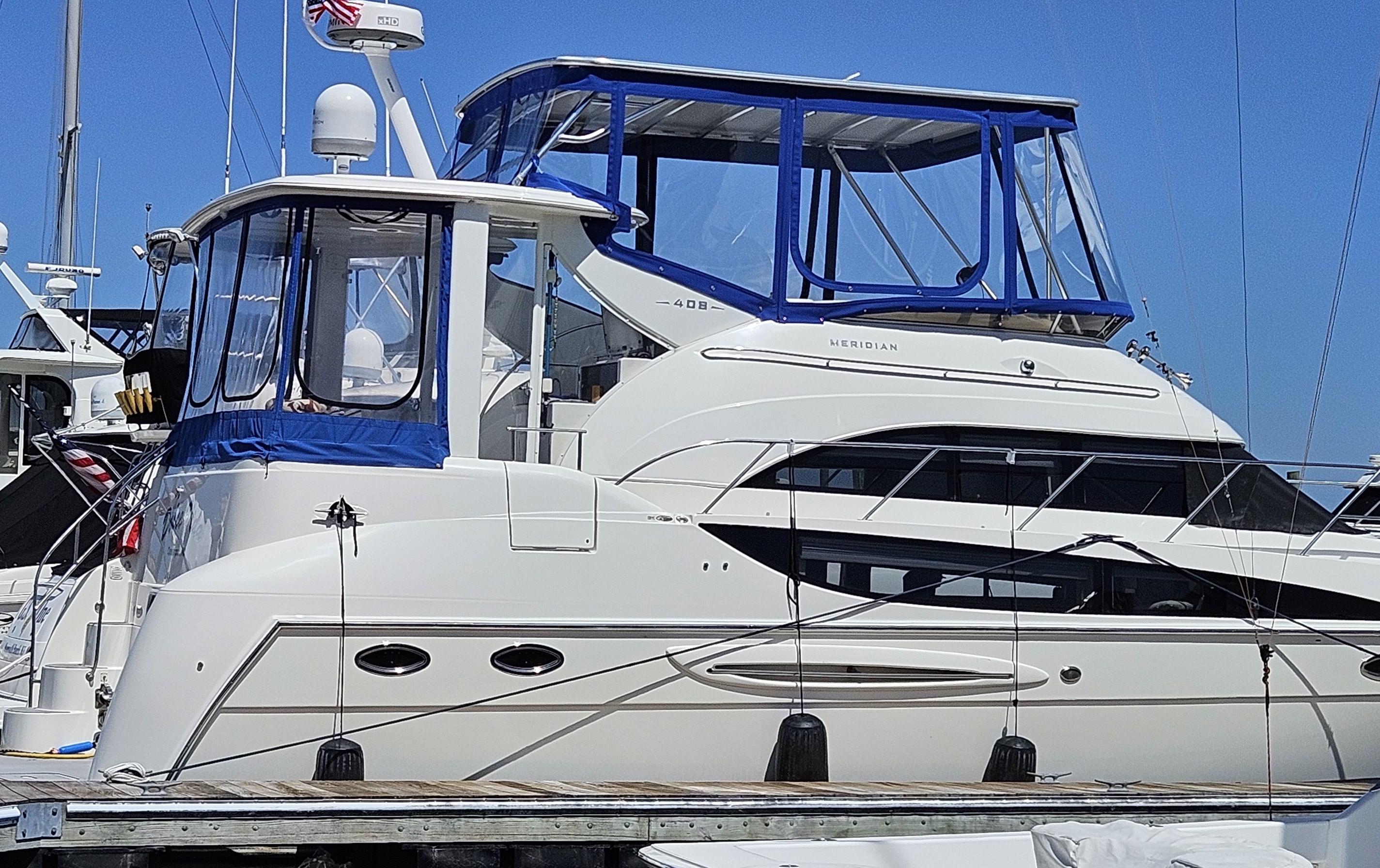 Atlantic Towers Top installed on a Meridian boat, showcasing a blue canvas cover and clear windows at the marina.