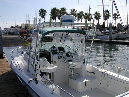 Atlantic Towers Arch installed on Neptune 23 Sunbird boat docked in marina with palm trees and other boats in background