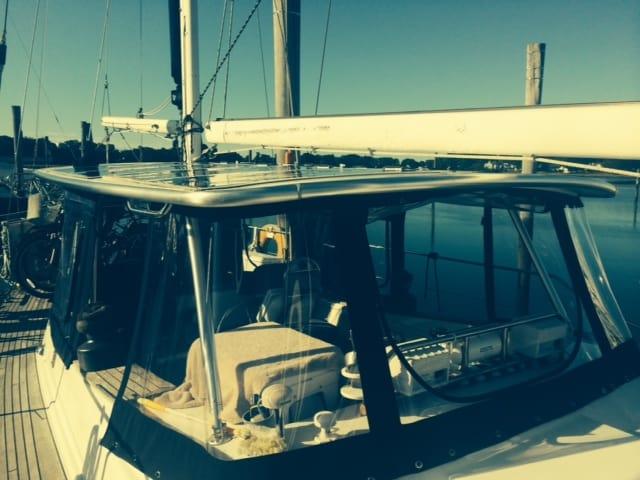 Atlantic Towers Top installed on a boat cabin, providing shade and protection, docked at a marina on calm water.