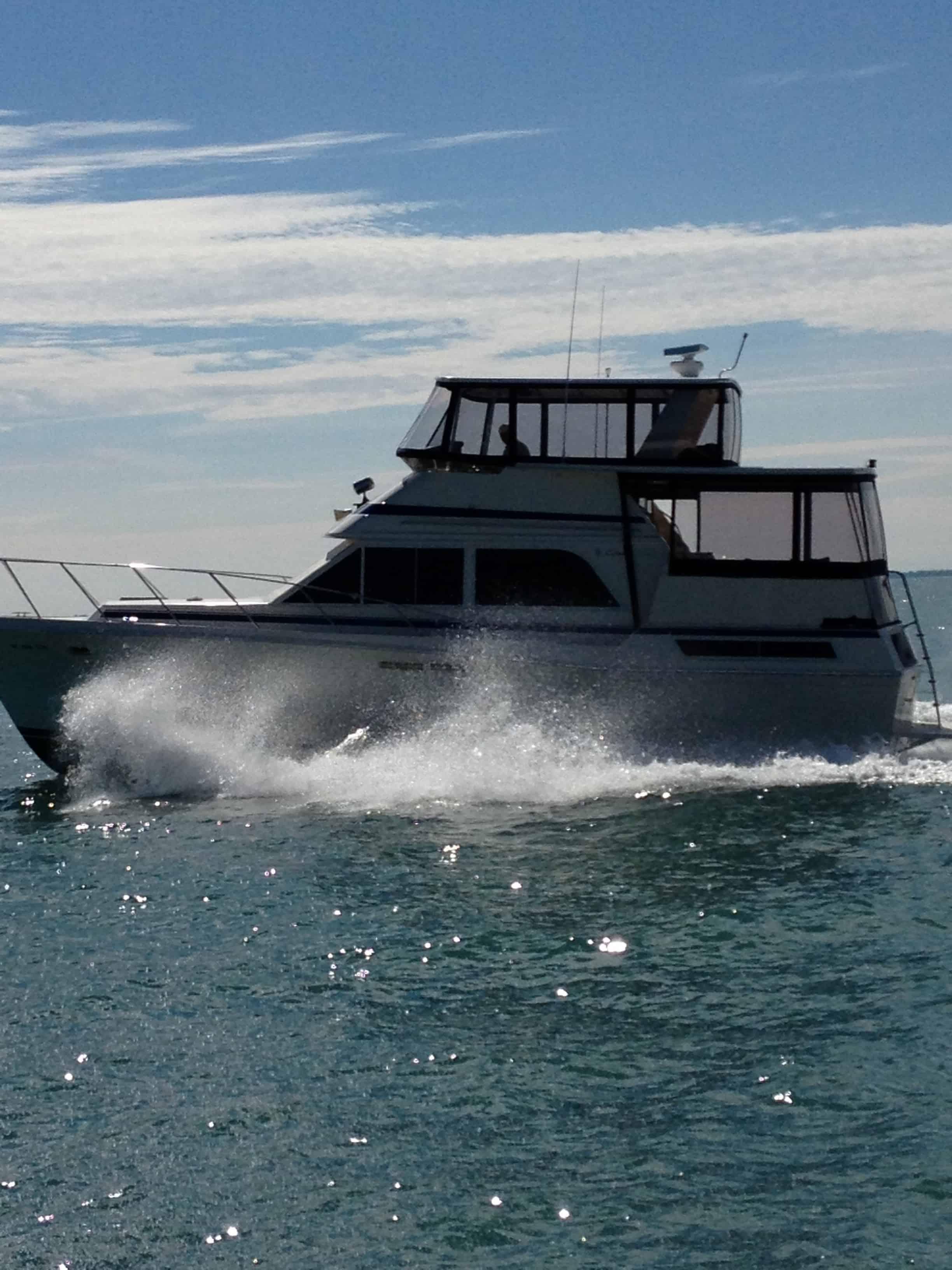 Atlantic Towers boat navigating through water, creating splashes with a clear blue sky in the background.