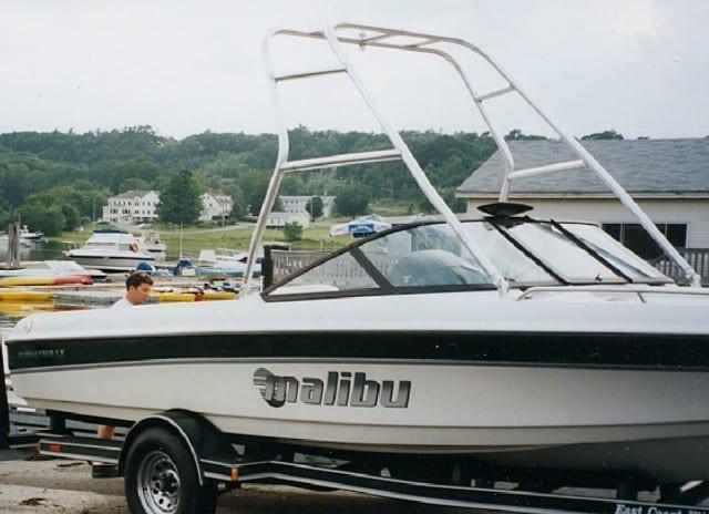 Malibu Sunsetter LX boat with installed Atlantic Towers Air Tower on trailer near waterfront with houses in background