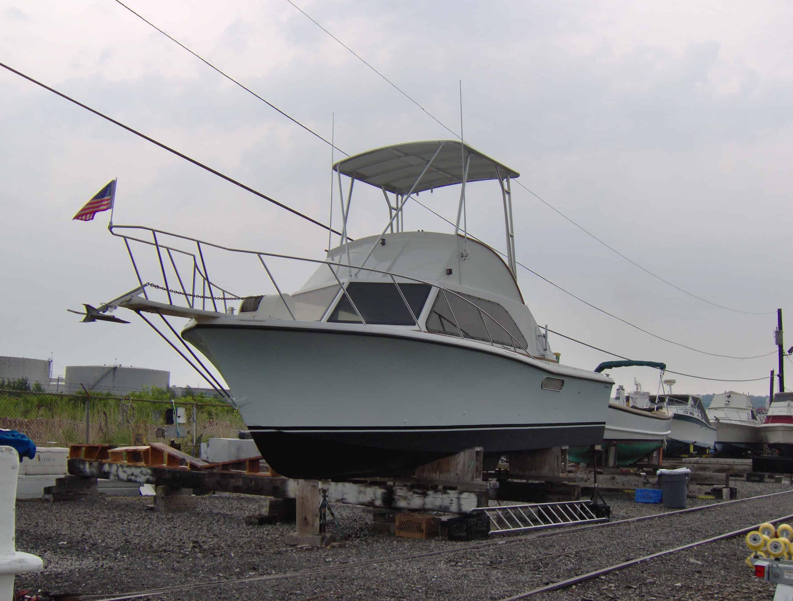 Jersey 31 all wood boat with installed Atlantic Towers Top mounted on dry dock with other boats in the background.