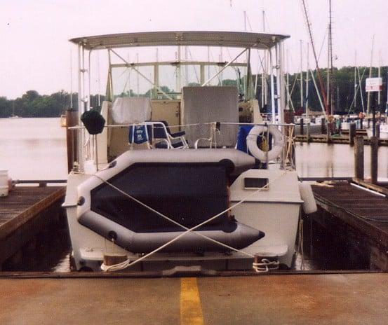 Bertram Motoryacht docked at a marina with an installed Atlantic Towers Top canopy and inflatable dinghy on the stern.