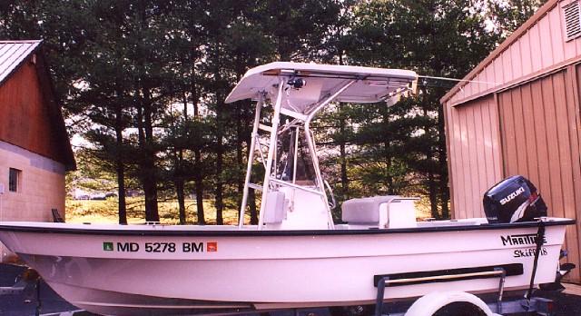 Atlantic Towers T-Top installed on a Maritime Skiff boat, parked in a yard with trees in the background.