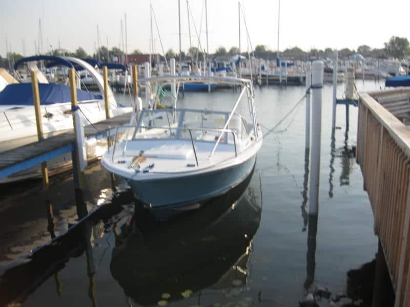 Bertram 25 open boat equipped with Atlantic Towers Top docked at a marina among other boats on calm water