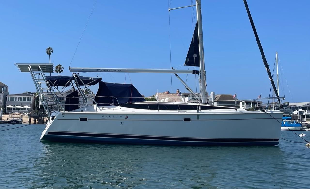 Atlantic Towers Arch installed on a Hunter sailboat moored in a marina under clear blue skies.