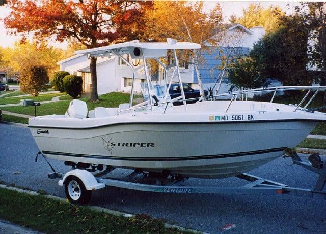 White Seaswirl 2100/2101 WA boat on trailer with Atlantic Towers T-Top parked on residential street in autumn setting