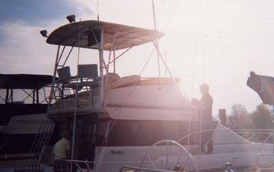 Atlantic Towers Top installed on Silverton 37 Convertible boat with people aboard in a marina at sunset.