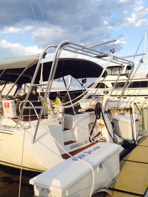 Stern view of a Beneteau boat docked with an installed Atlantic Towers Arch supporting a black canopy and rigging lines.