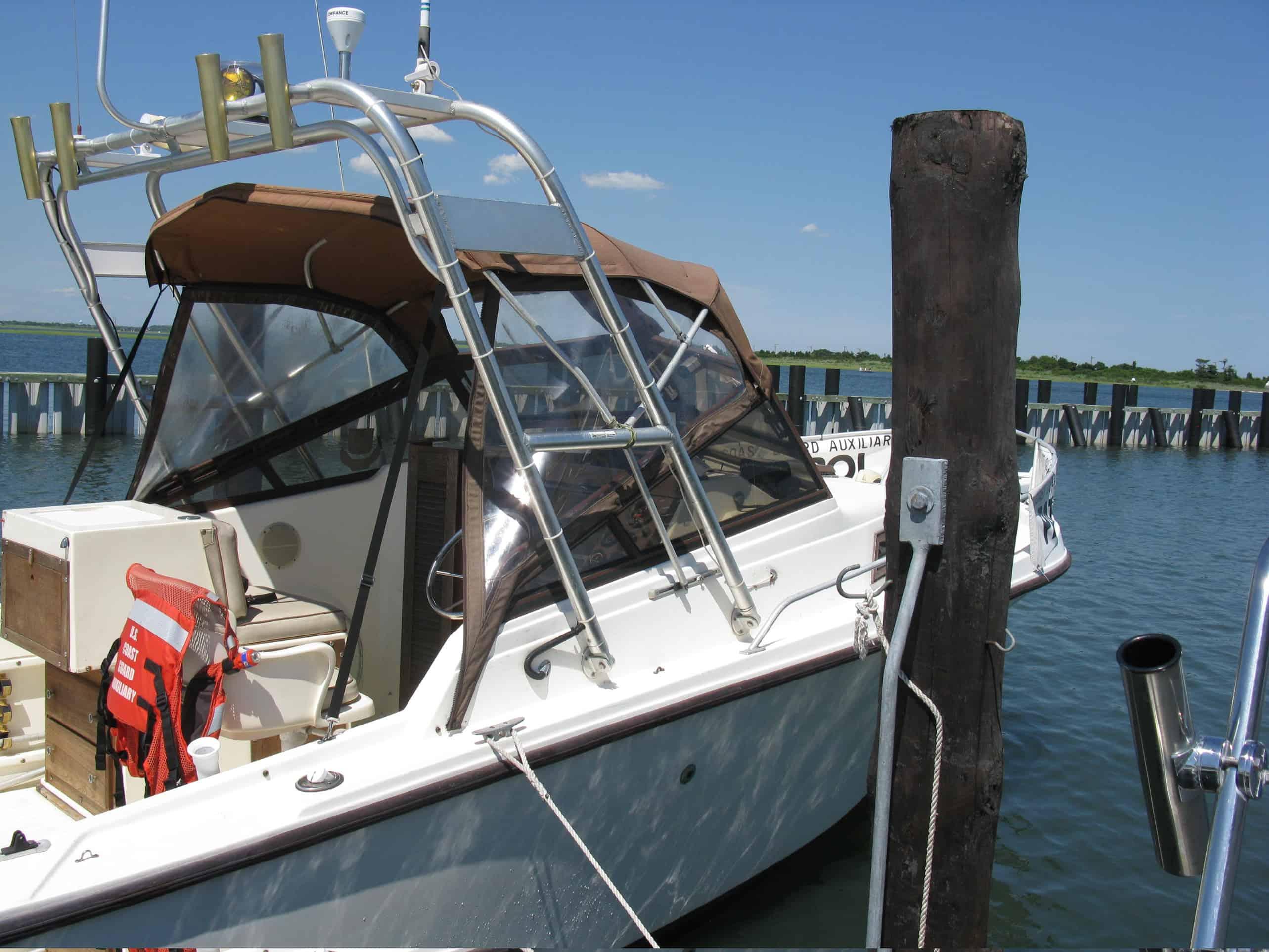 Atlantic Towers arch installed on a Mako 250 boat docked near a wooden post with blue water in the background.