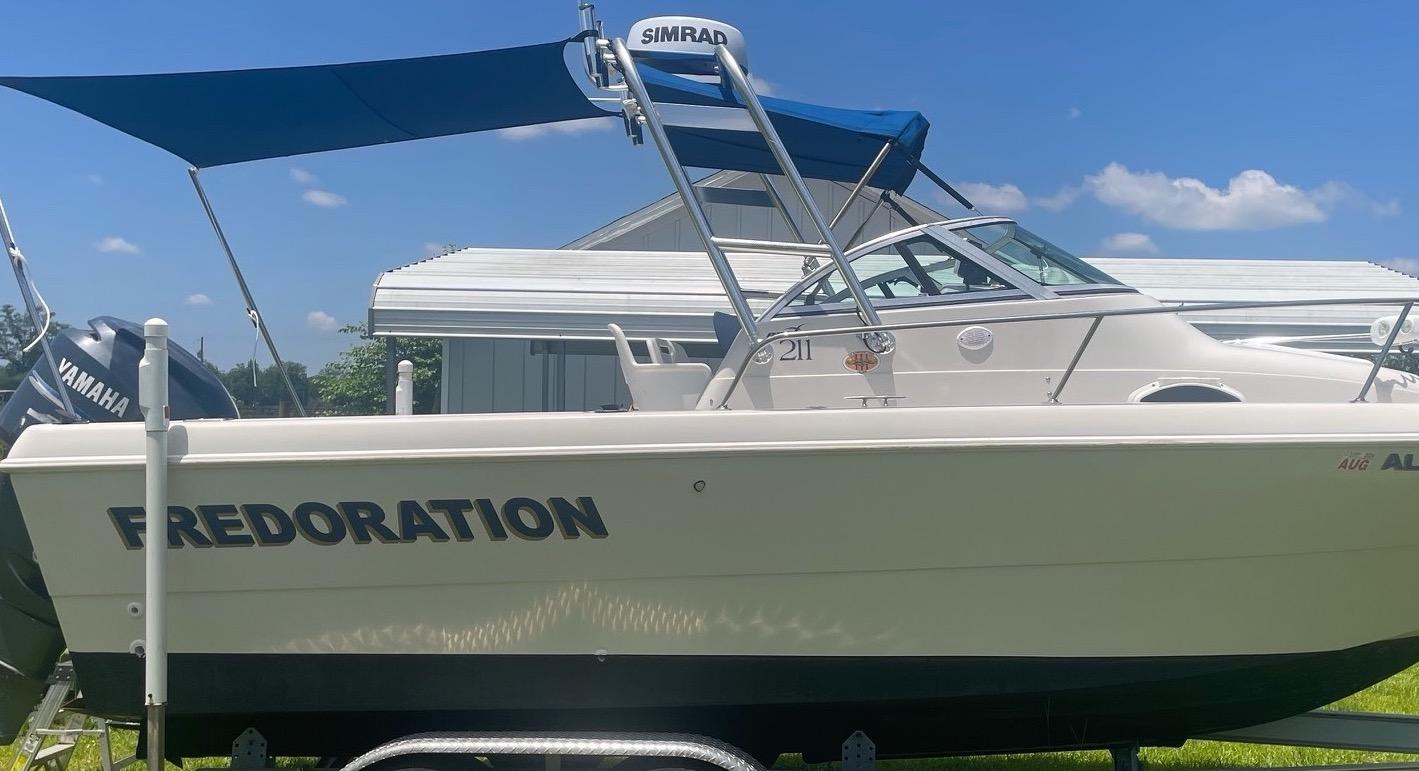 Atlantic Towers Arch installed on a Pro Line boat with a blue bimini top and Yamaha engine, set against a clear blue sky.