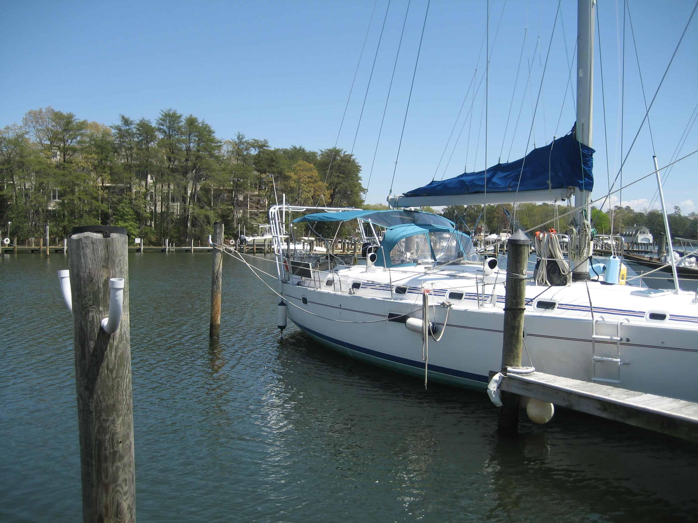 Atlantic Towers Arch installed on a Beneteau boat docked in a marina with calm water and trees in the background.