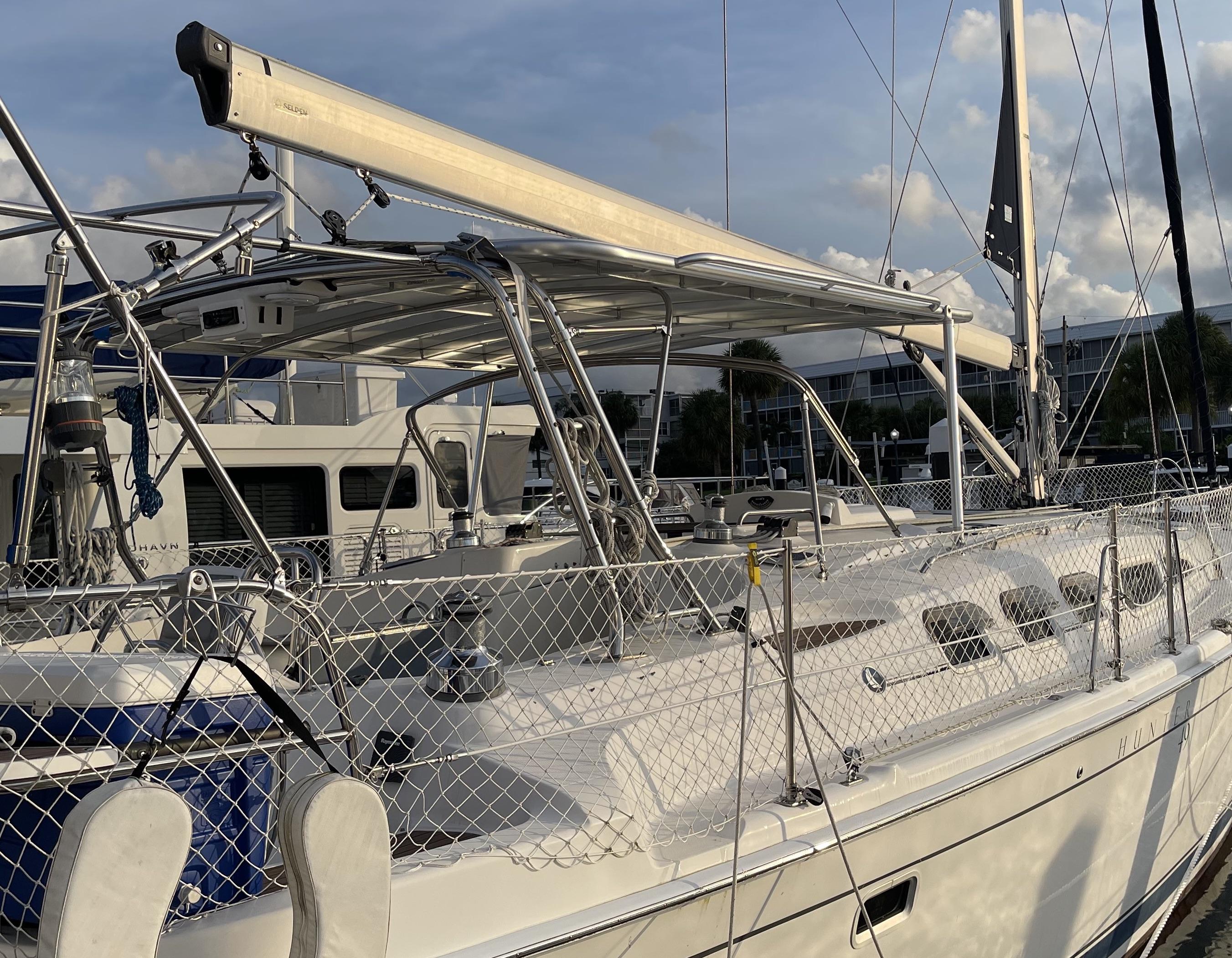 Atlantic Towers Top installed on deck of Hunter sailboat docked at marina with lines and rigging visible under blue sky.