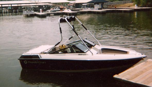 Thundercraft boat with installed Atlantic Towers Air Tower docked at a pier in a calm lake marina.