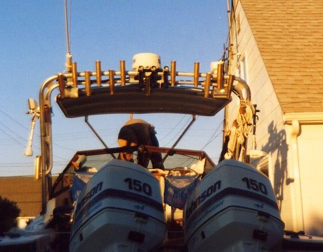 Atlantic Towers boat arch installed on a boat with dual 150-horsepower Johnson outboard motors docked beside a building.