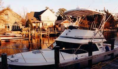 Atlantic Towers Top installed on Blackfin 29 Flybridge boat docked near waterfront houses during sunset.
