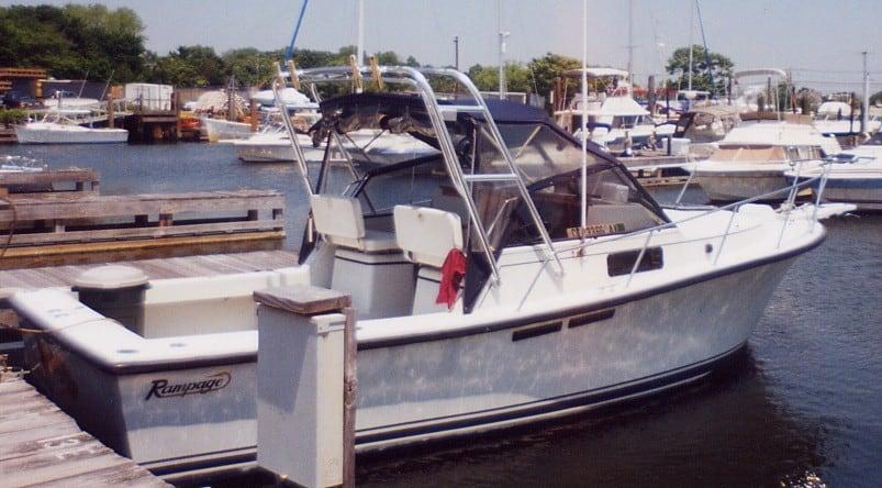 Atlantic Towers Arch installed on a Rampage 28 Sportsman boat docked at a marina with other boats visible.