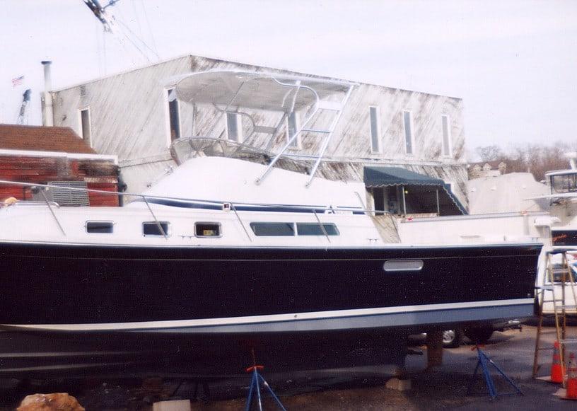 Albin Command Bridge boat with Atlantic Towers Top installed, docked on stands next to a building.