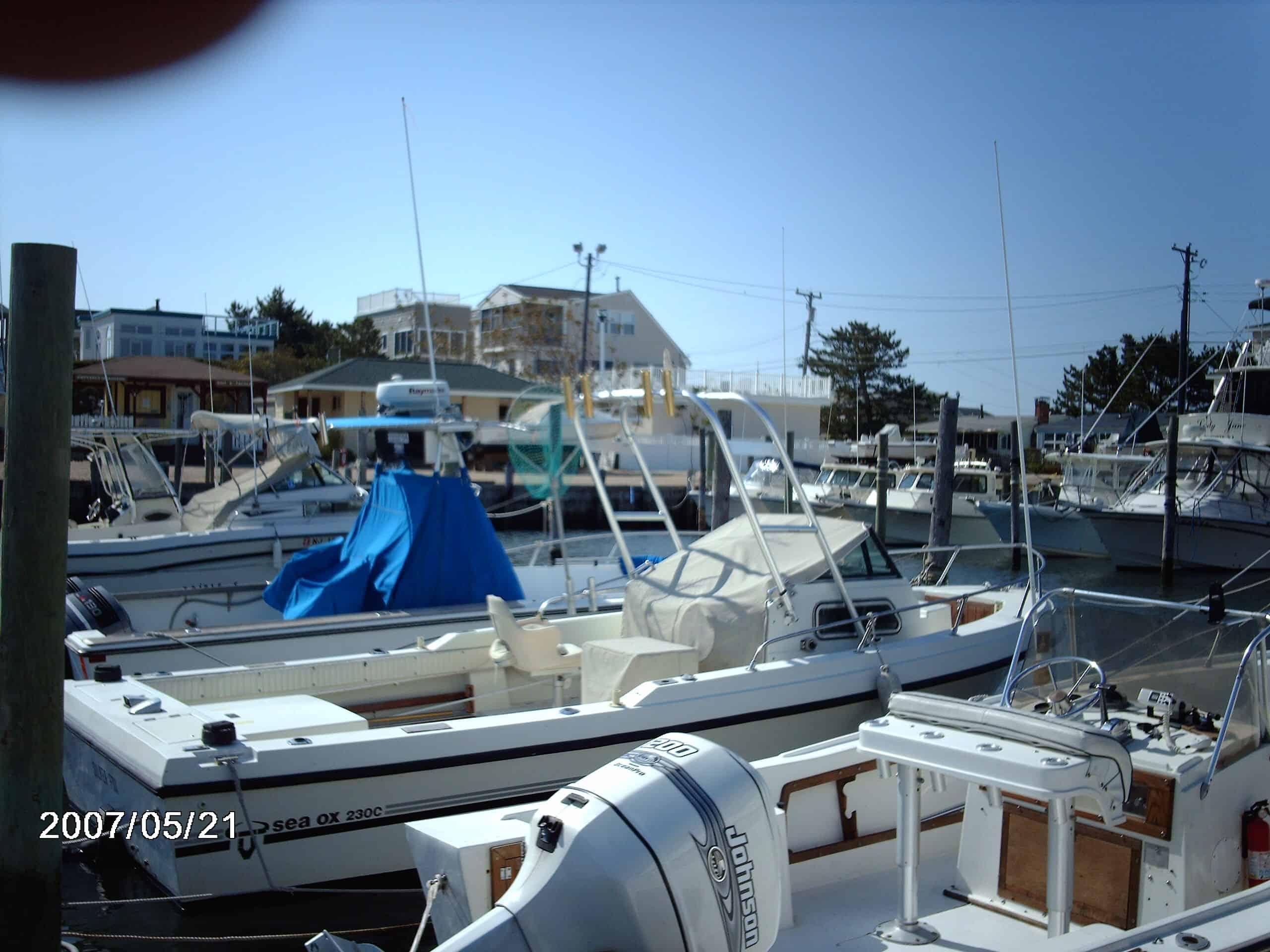 Atlantic Towers Arch installed on Sea Ox 230C walkaround boat, shown moored at a marina dock.