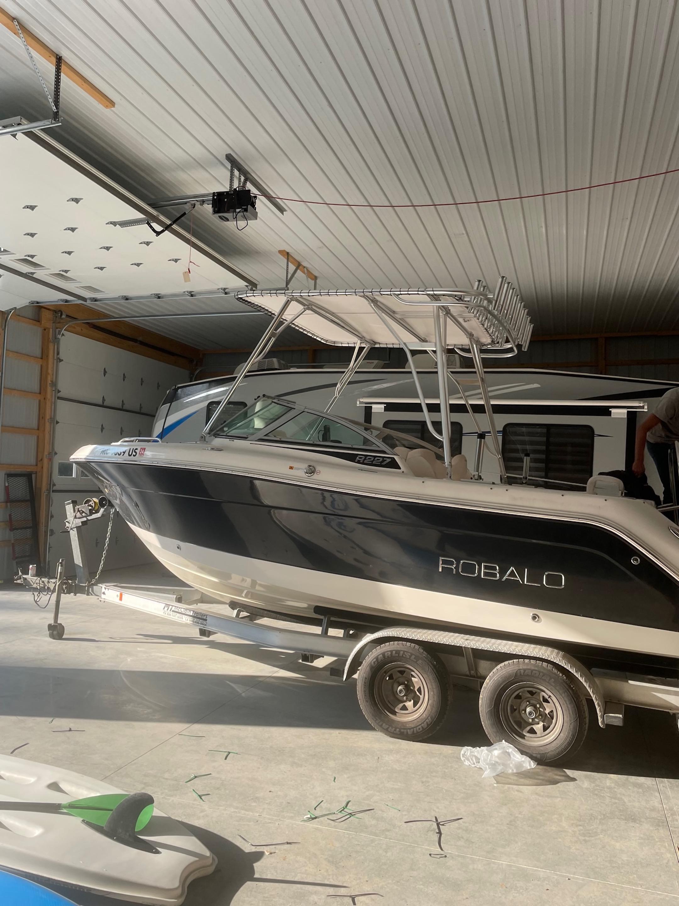 Atlantic Towers Top installed on a Robalo boat in a garage, showcasing the boat's sleek design and storage setup.