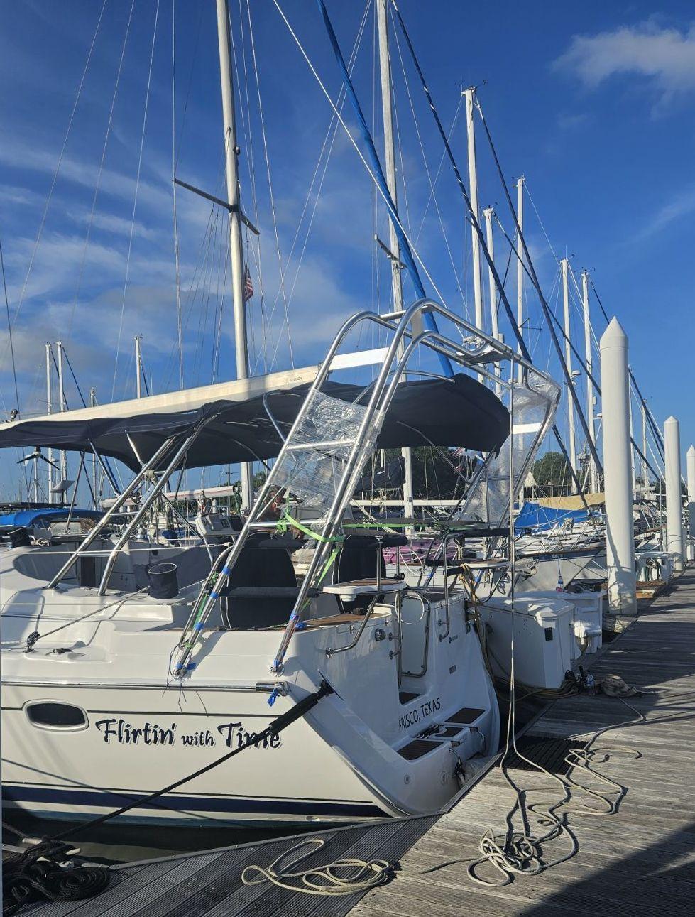 Atlantic Towers arch installed on a Hunter boat named "Flirtin' with Time" at the marina, with masts in the background.