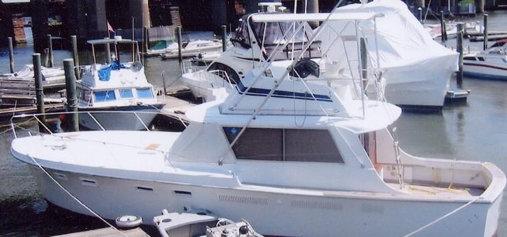 Atlantic Towers Top installed on a white Hattaras 41 C boat docked at a marina with other boats nearby.