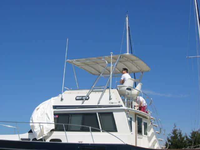 Atlantic Towers Top installed on a Californian 38 Convertible boat with people on the flybridge against a clear blue sky.