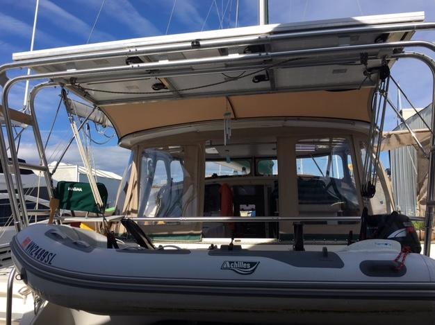 Atlantic Towers Arch installed on a Fountaine Pajot boat with a dinghy attached at the stern under a clear sky.