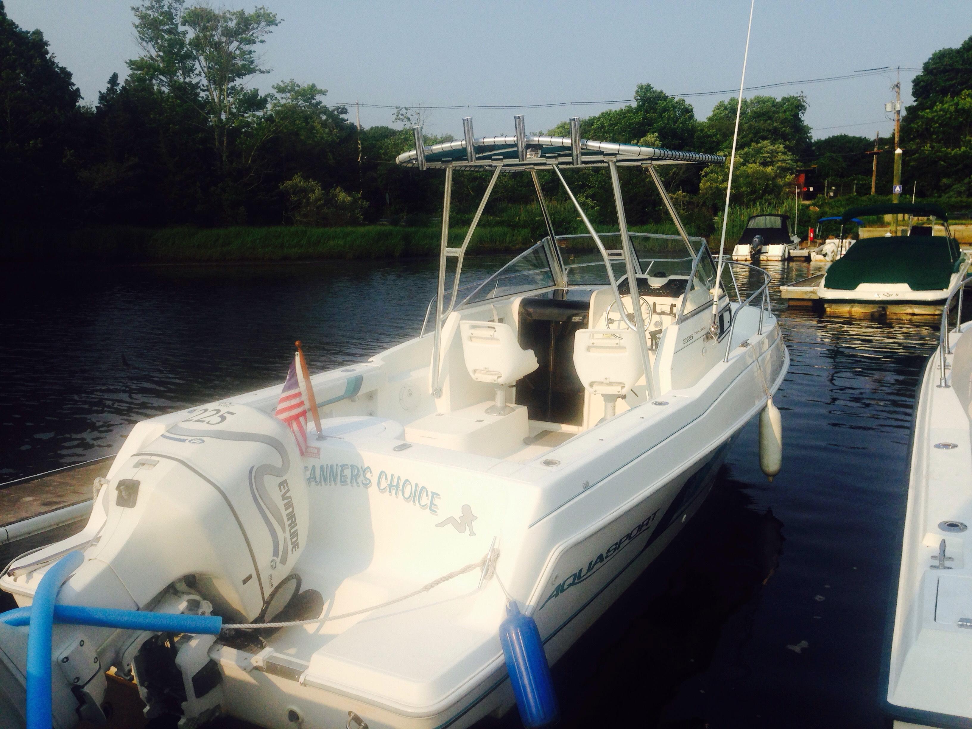 White Aquasport boat docked with Atlantic Towers Top installed above the helm area, equipped with fishing rod holders.