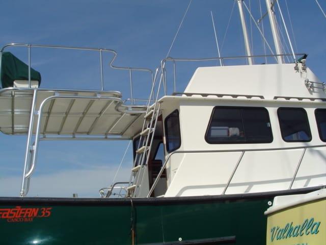 Atlantic Towers Cockpit Sun Shade installed on an Eastern Boats 35, showcasing the boat's upper deck and windows.