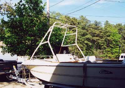 Atlantic Towers Air Tower installed on a white Cruisers Console boat docked near trees and parked vehicles.