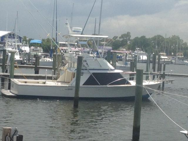 Blackfin boat docked in marina with Atlantic Towers Top installed on the upper deck under partly cloudy sky