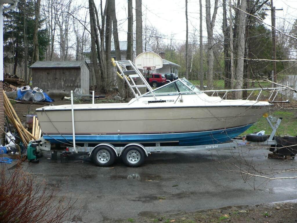 Atlantic Towers Arch installed on a Tiara 2500 Cuddy boat, parked on a trailer in a wooded area.