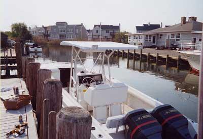 Atlantic Towers T-Top on a Wellcraft 30 Scarab Sport moored by a dock in a residential area.