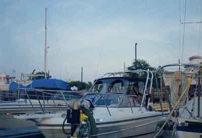 Atlantic Towers Arch installed on a Robalo 2160 Cuddy boat at a marina with other vessels in the background.