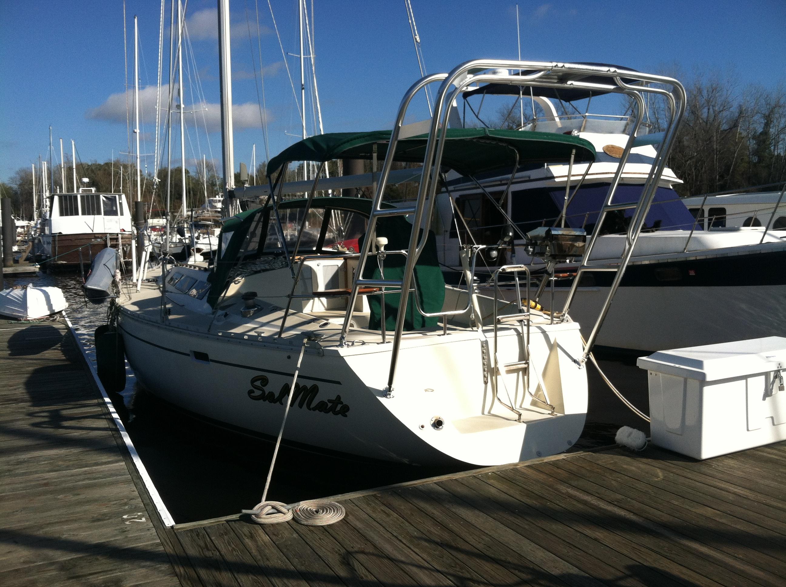 O'Day sailboat docked with installed Atlantic Towers arch supporting solar panels and green canvas covers.