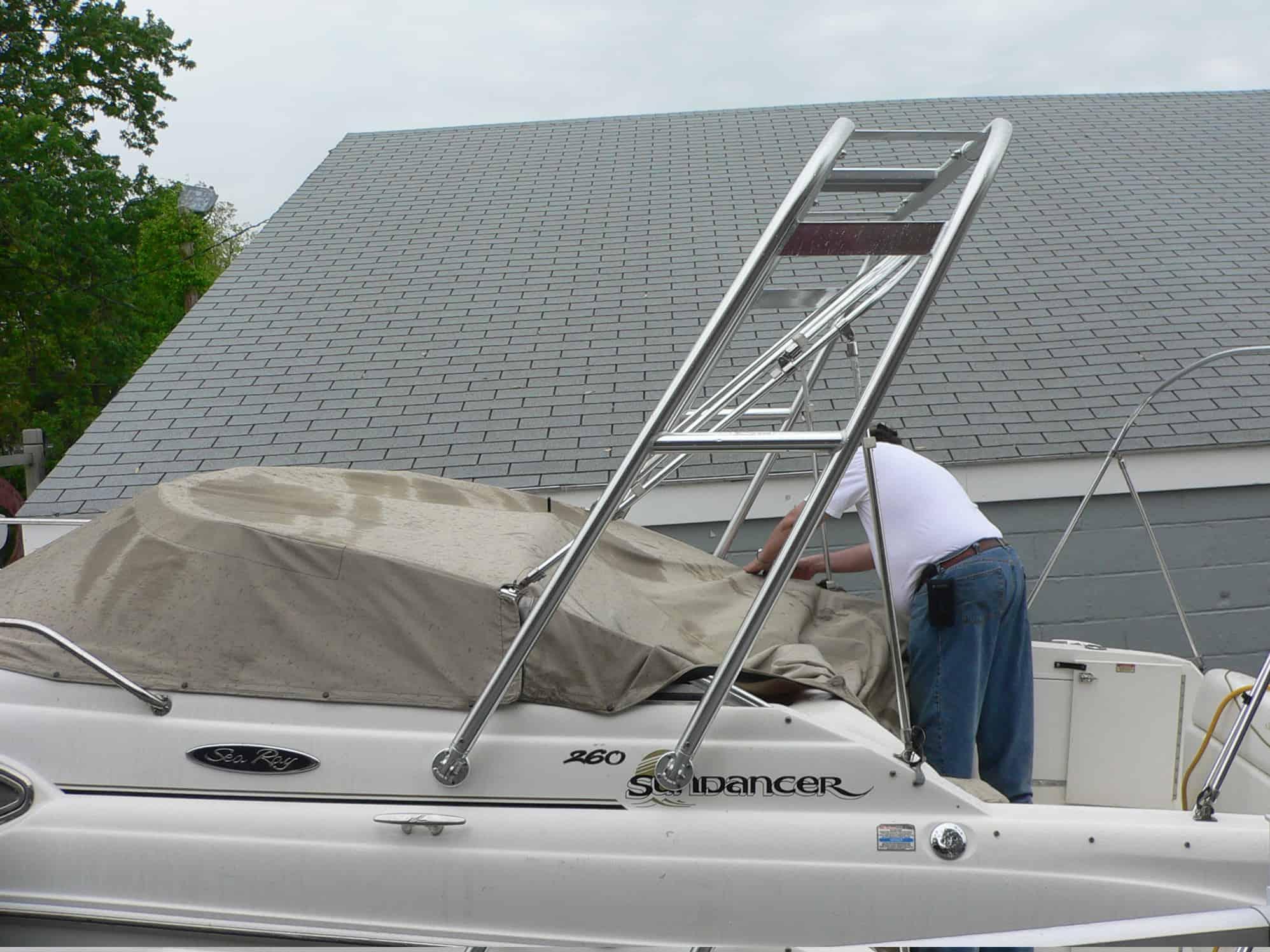 Atlantic Towers Arch installed on a Sea Ray 260 Sundancer boat, with a person adjusting the boat cover.