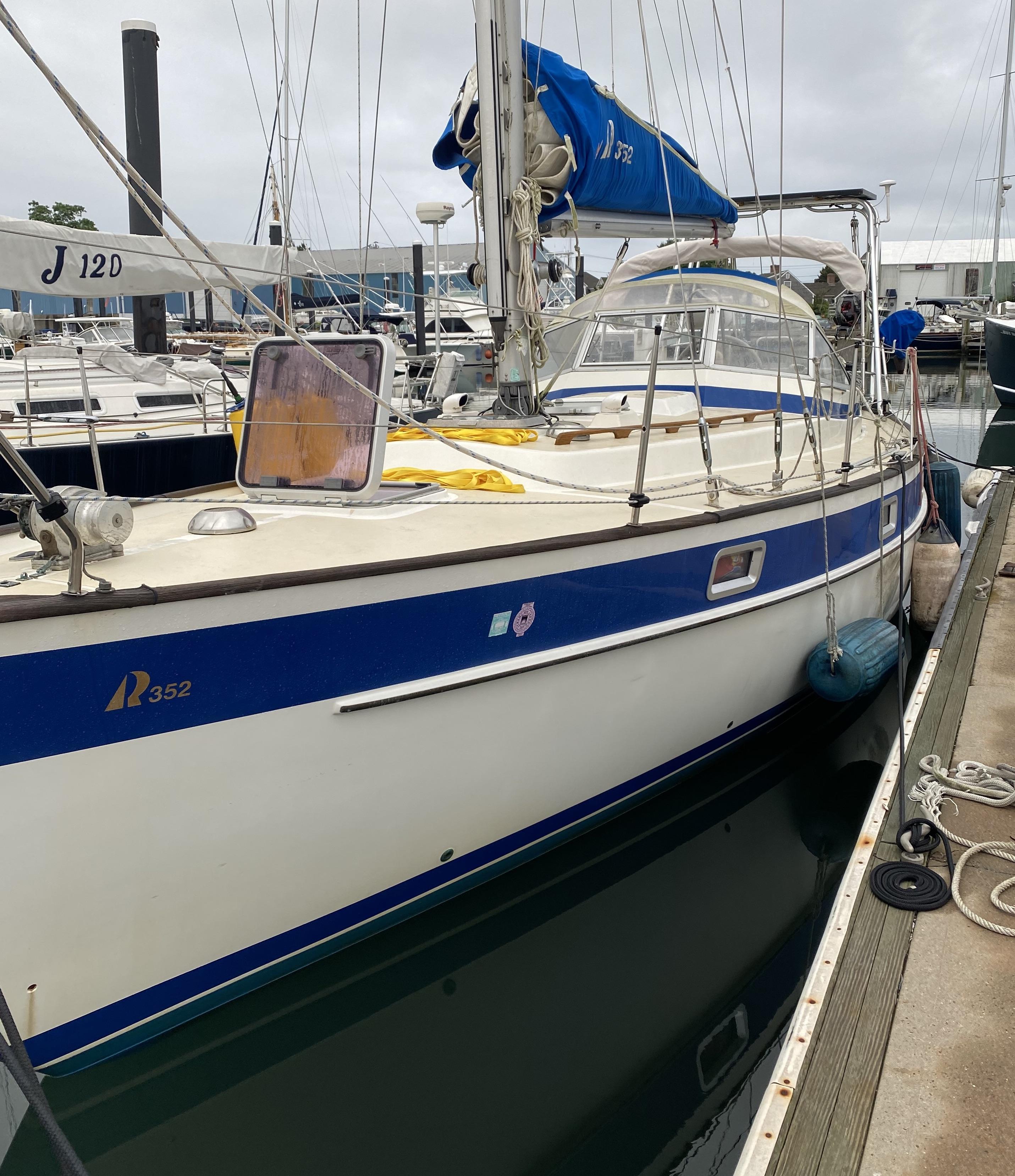 Atlantic Towers Arch installed on a Hallberg-Rassy boat, docked at a marina with various sailing vessels.