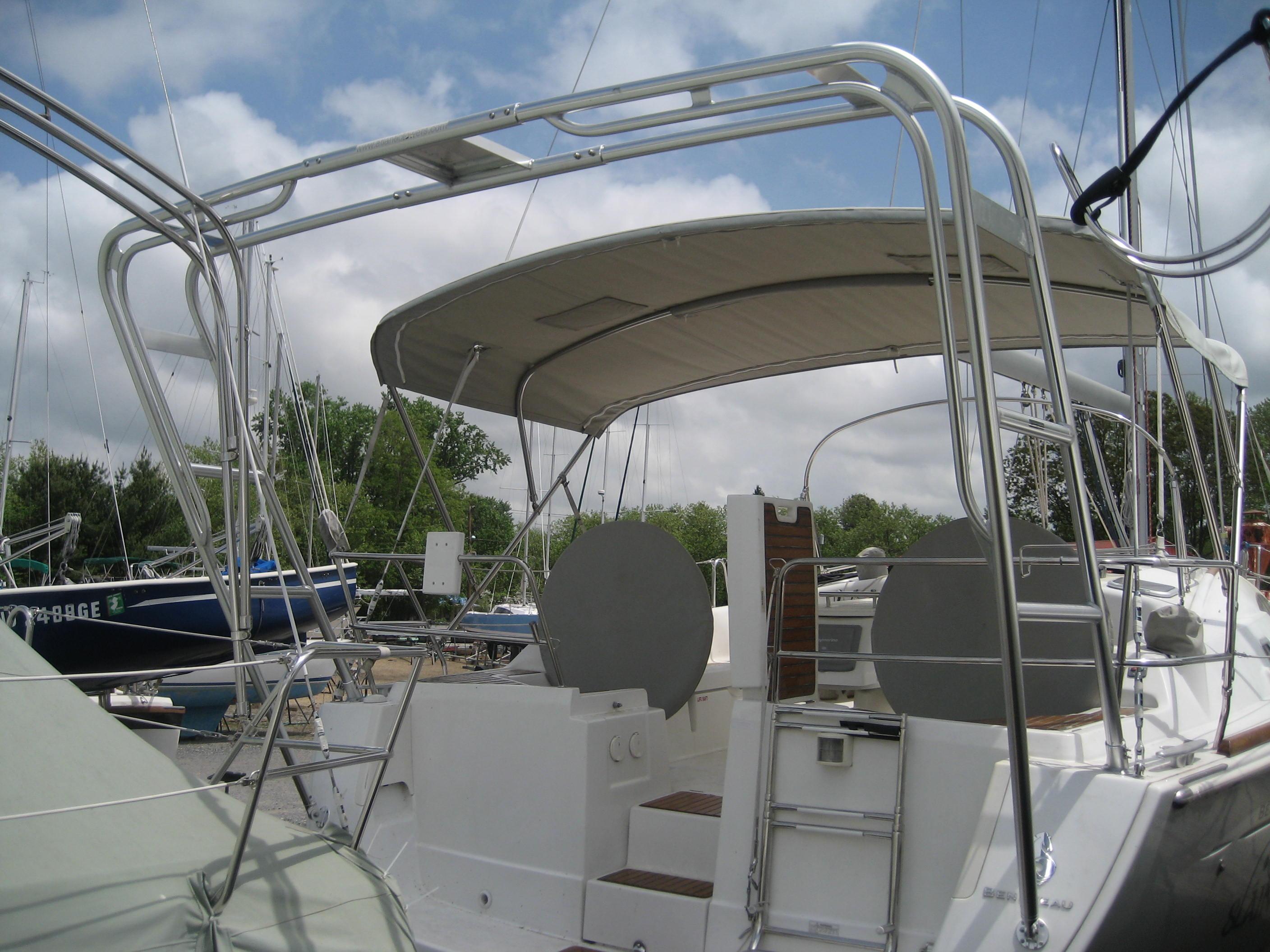 Atlantic Towers Arch installed on a Beneteau boat, featuring a metal frame and a fabric cover, with a marina backdrop.