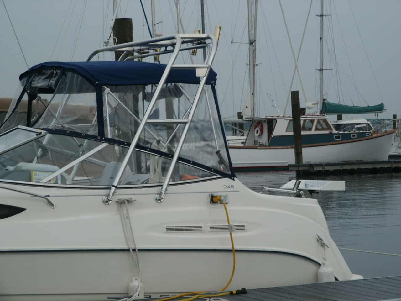 Side view of a Glacier Bay 2640 Renegade boat docked, featuring an installed Atlantic Towers arch with a blue canvas cover.