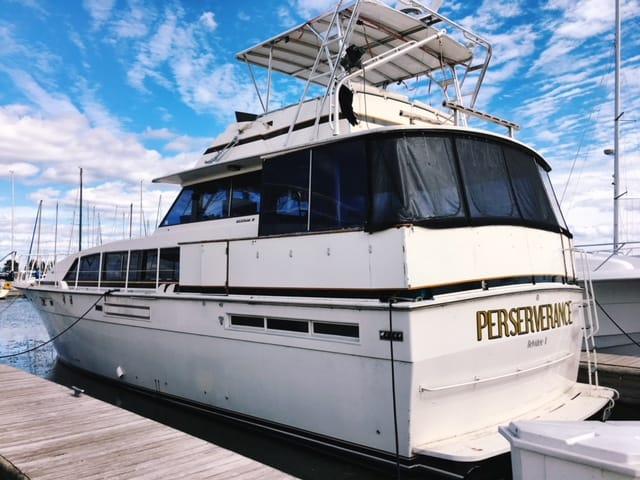 Atlantic Towers Top installed on a Bertram boat docked at a marina with sailboats in the background.