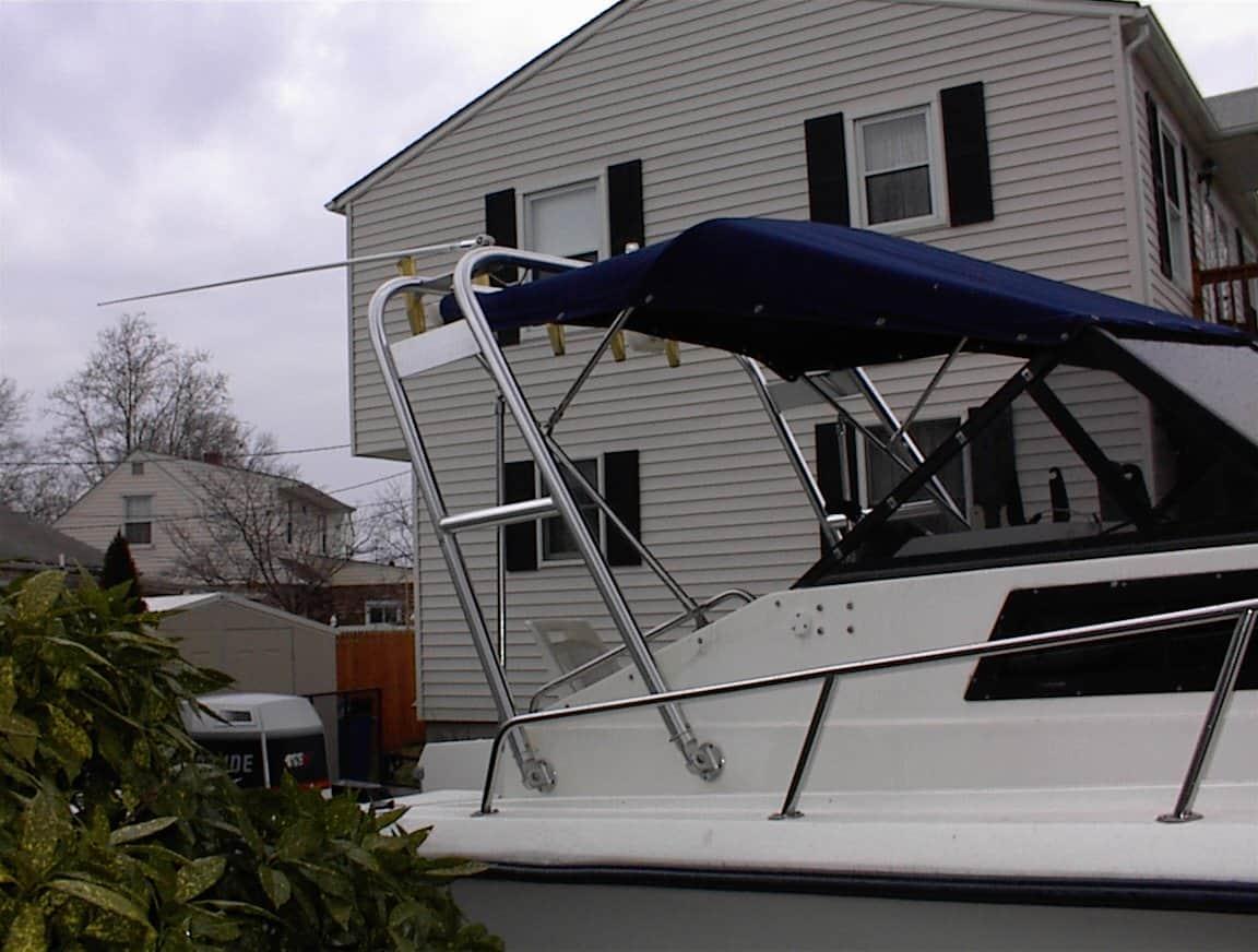 Atlantic Towers arch installed on an Angler Boats model with navy blue canopy in a residential backyard setting