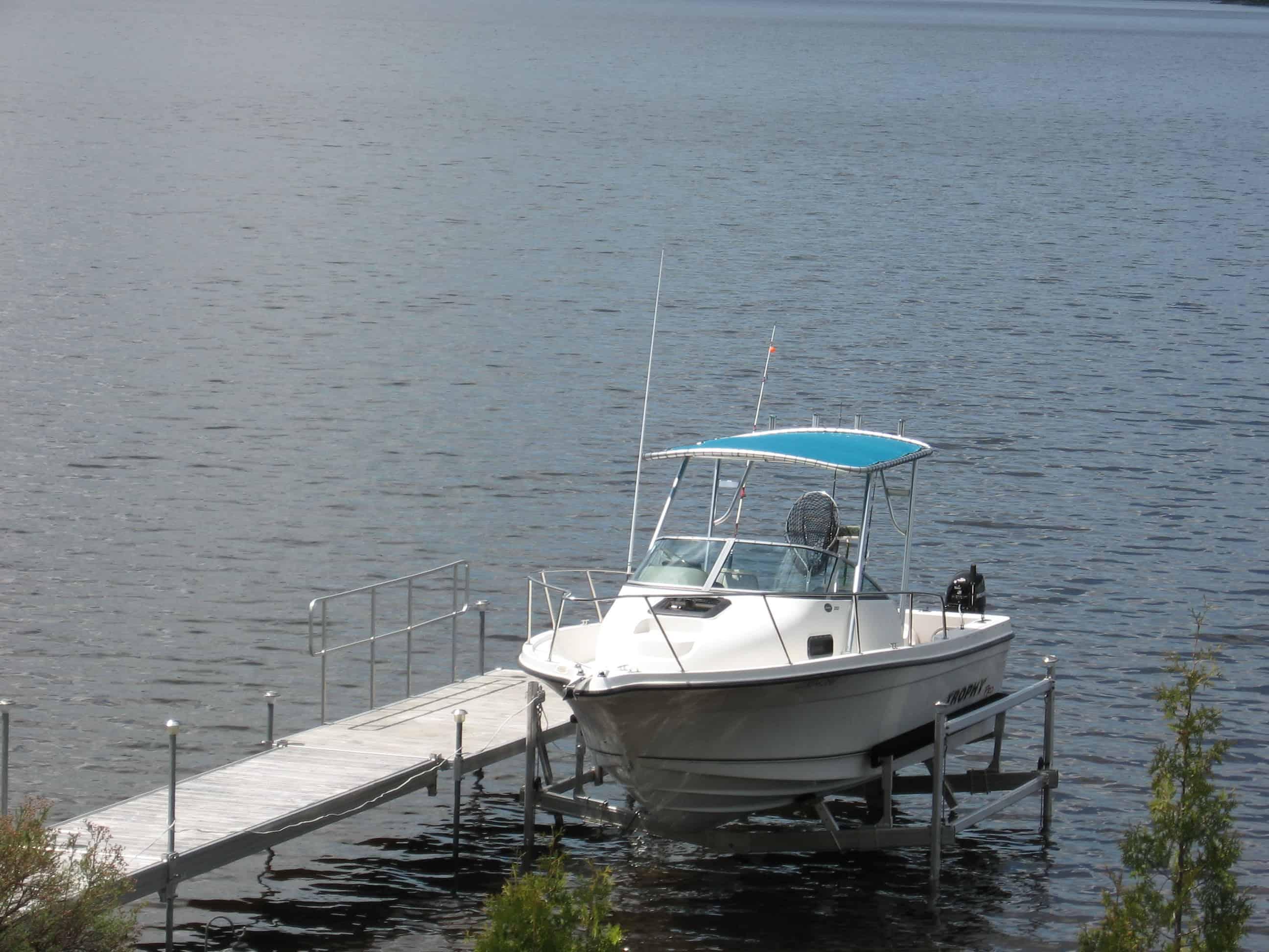 Atlantic Towers Top installed on a white Trophy 2052 walkaround boat docked on calm water under a clear sky.