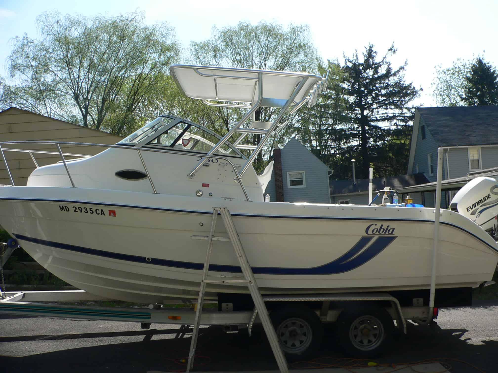 Atlantic Towers Top installed on a white Cobia 230/240/250 walkaround boat on a trailer near residential houses