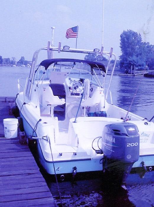 Atlantic Towers Arch installed on a Team Sailfish 234WA boat, docked beside calm waters with a flag flying.